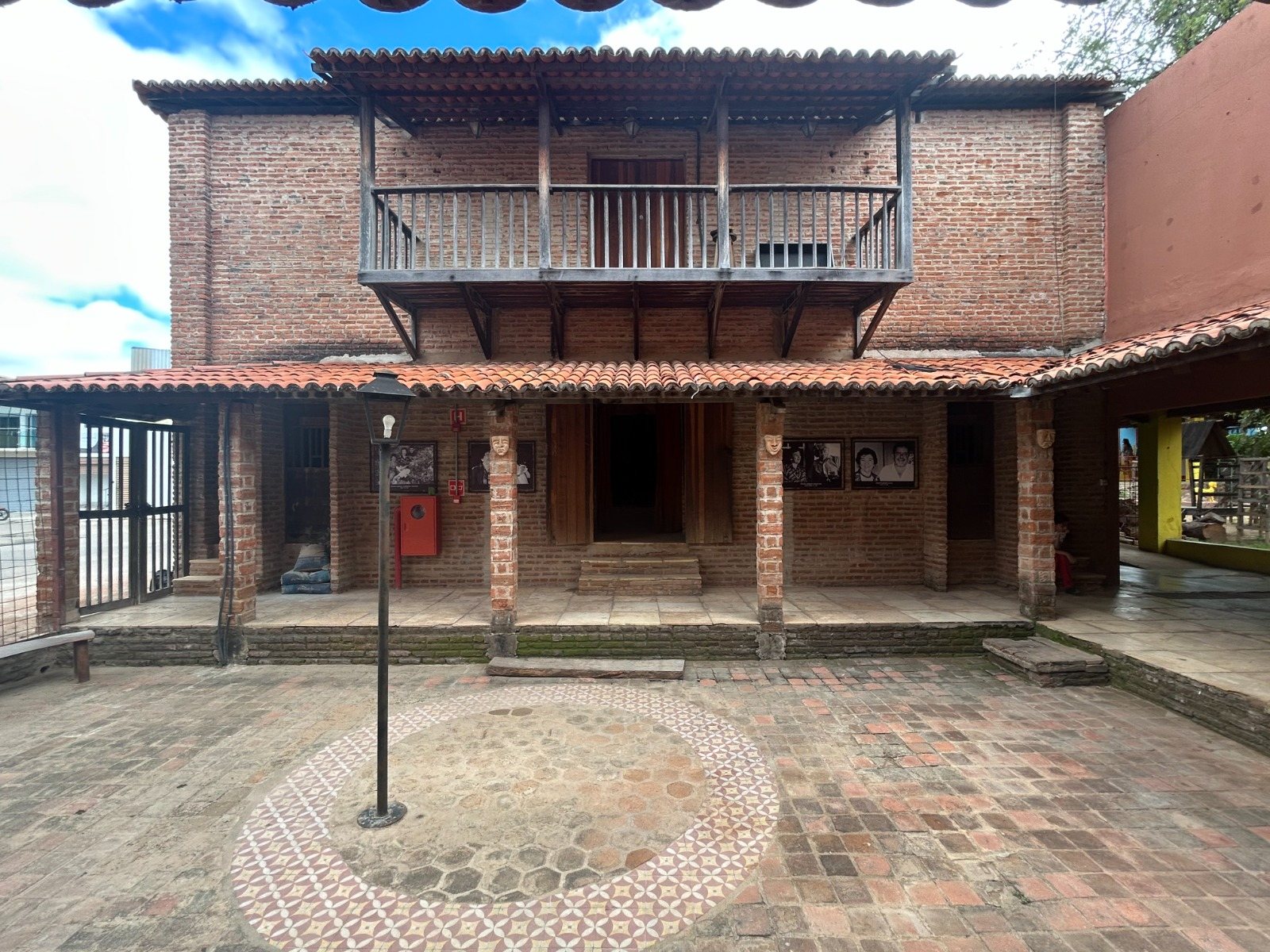 Fachada de tijolo aparente do Teatro Violeta Arraes, com varanda de madeira
